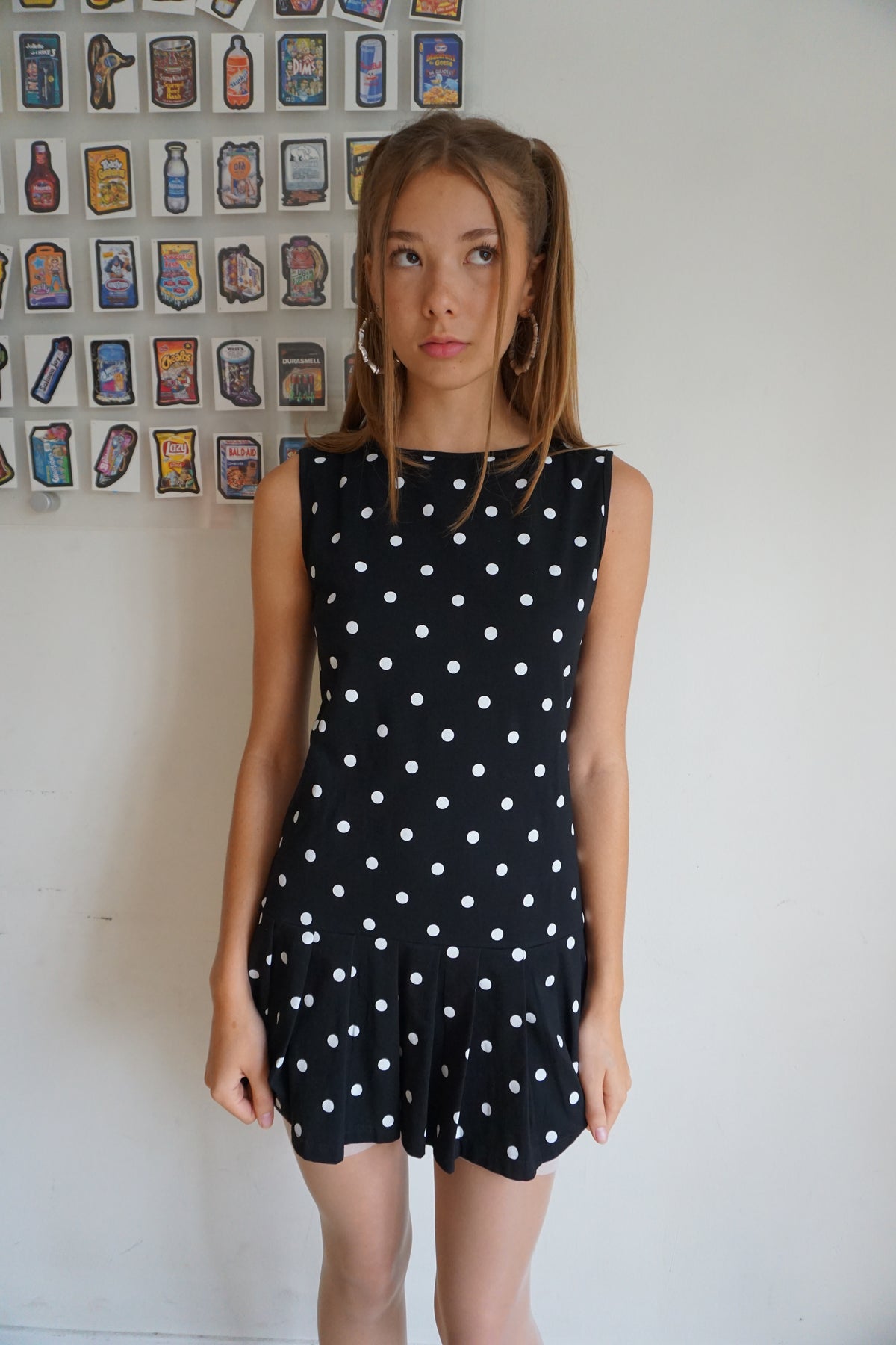 Girl wearing a pleated drop waist black and white polka dot dress