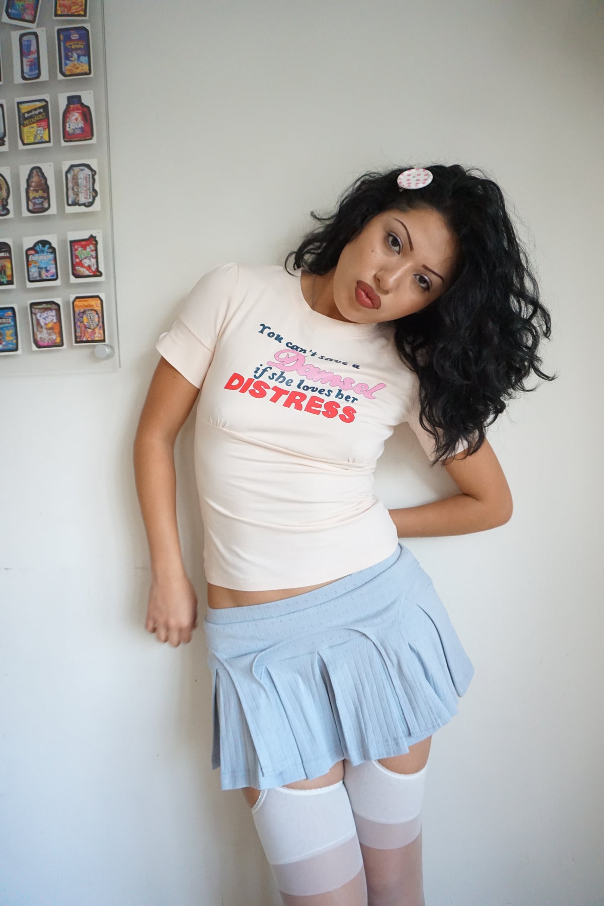 peach pink t shirt with buttons on the sleeve and a graphic that says "you can’t save a damsel if she loves her distress"