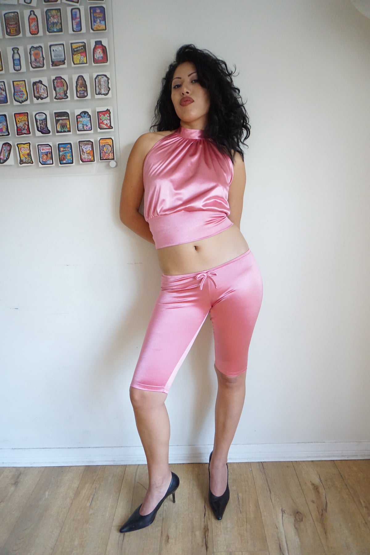 Girl wearing satin pink capris with a bow and a matching halter top 