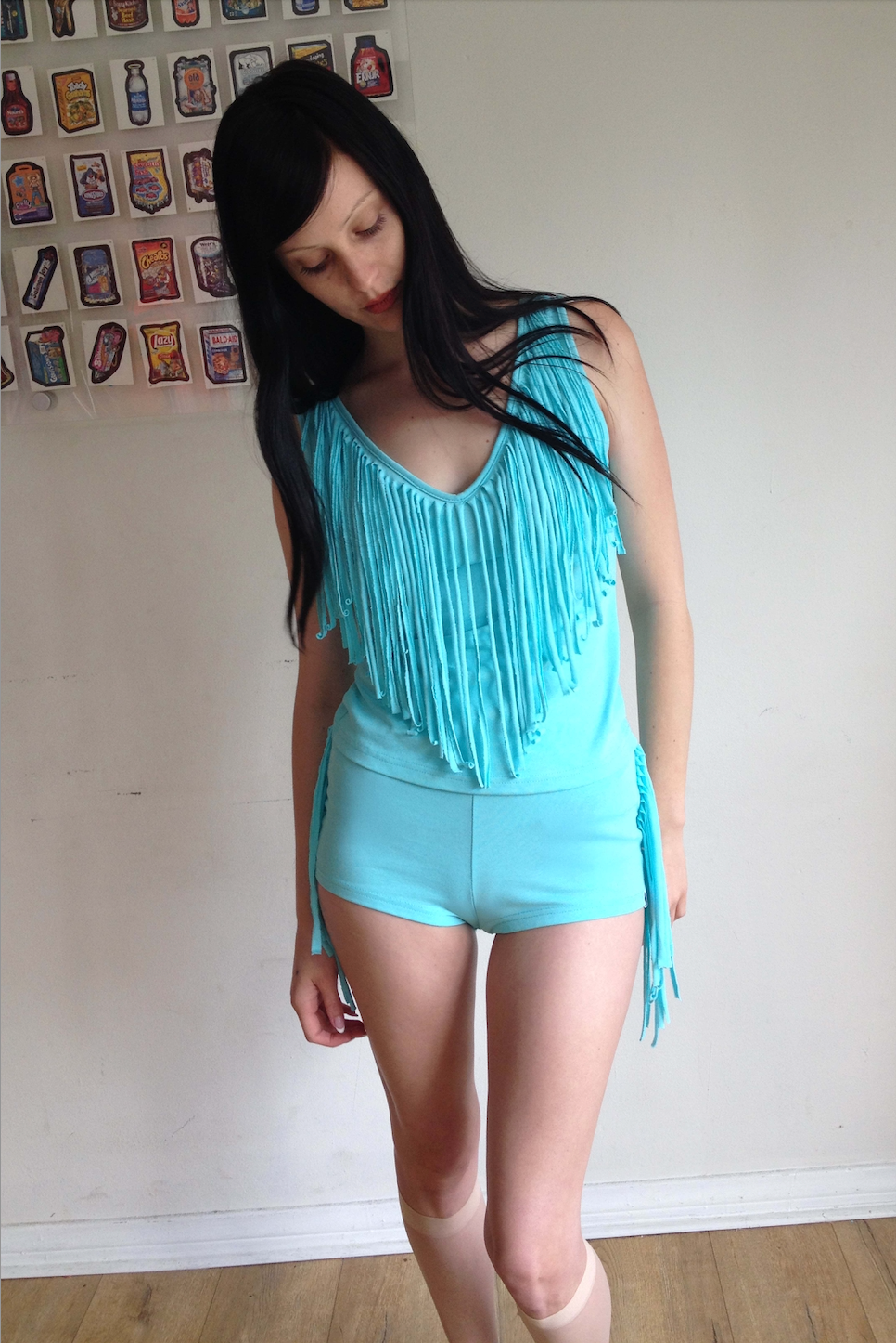 girl wearing teal blue micro shorts with fringe on the side and a matching top 